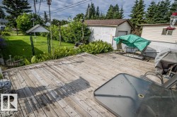 Expansive wood-finish deck extending to a manicured lawn area - 