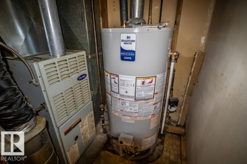 Bradford White water heater with copper piping and a Carrier furnace system - 5009 47 Ave, St. Paul Town, AB - Indoor Photo Showing Basement