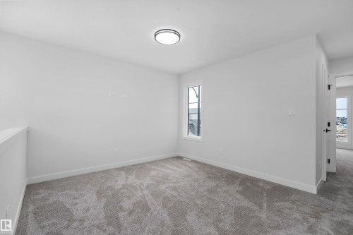 Neutral carpet flooring, white painted walls, a single window, and an overhead flush-mount light fixture - 1737 Crossbill Loop Nw, Edmonton, AB - Indoor Photo Showing Other Room