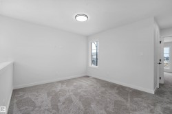 Neutral carpet flooring, white painted walls, a single window, and an overhead flush-mount light fixture - 
