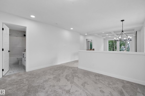 Spacious primary suite featuring polished concrete flooring, recessed ceiling lighting, and a modern pendant fixture - 1737 Crossbill Loop Nw, Edmonton, AB - Indoor Photo Showing Other Room