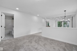 Spacious primary suite featuring polished concrete flooring, recessed ceiling lighting, and a modern pendant fixture - 