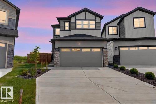 Modern two-story residence featuring light gray siding and dark trim accents - 347 Bluff Cove, Leduc, AB - Outdoor With Facade
