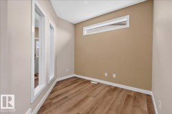 Room featuring wood-finish flooring, a contemporary transom window, and a neutral color palette - 