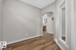 Wood-finish flooring throughout, complemented by a light gray wall color and white trim - 