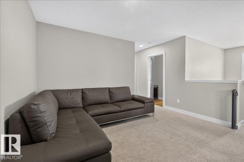 Loft space featuring neutral wall tones, textured ceiling, and plush carpeting - 347 Bluff Cove, Leduc, AB - Indoor Photo Showing Living Room
