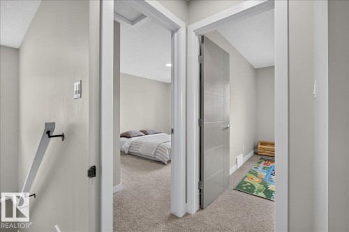 Carpeted hallway with light gray walls and white trim - 347 Bluff Cove, Leduc, AB - Indoor