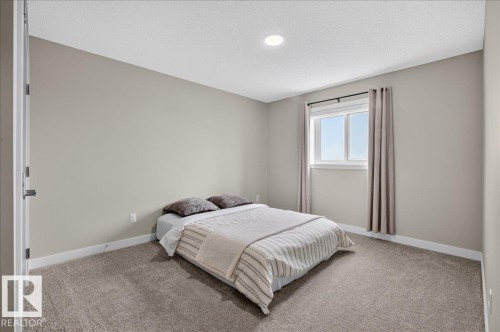 Bedroom featuring neutral wall paint, recessed lighting, white baseboards, and window with dark curtain rod - 347 Bluff Cove, Leduc, AB - Indoor Photo Showing Bedroom