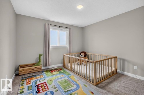 Neutral-toned room featuring a recessed ceiling light, a double window with drapes, and carpeted flooring - 347 Bluff Cove, Leduc, AB - Indoor Photo Showing Bedroom