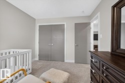 Soft gray walls complement the neutral carpeting in this room featuring a closet with bi-fold doors - 