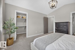 Spacious room featuring vaulted ceilings, light gray walls, plush carpeting, and a modern geometric ceiling light fixture - 