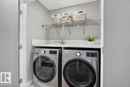 Dedicated laundry area with front-loading appliances, white countertop, white subway tile backsplash, and overhead wire shelving - 347 Bluff Cove, Leduc, AB - Indoor Photo Showing Laundry Room