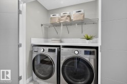 Dedicated laundry area with front-loading appliances, white countertop, white subway tile backsplash, and overhead wire shelving - 