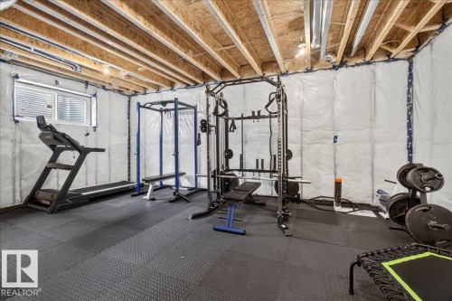 Unfinished basement with exposed ceiling joists and ceiling-mounted lighting - 347 Bluff Cove, Leduc, AB - Indoor Photo Showing Basement