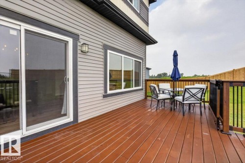Wood-finish deck with a black railing system and direct access to the interior via a sliding glass door - 347 Bluff Cove, Leduc, AB - Outdoor With Deck Patio Veranda With Exterior