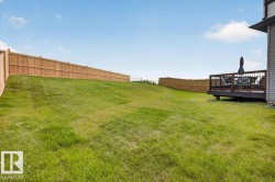 Expansive green lawn with a full privacy fence - 