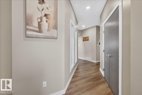 Hallway featuring wood-finish flooring, recessed lighting, and a modern bi-fold closet door - 347 Bluff Cove, Leduc, AB - Indoor Photo Showing Other Room