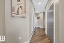Hallway featuring wood-finish flooring, recessed lighting, and a modern bi-fold closet door - 