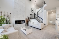 Vaulted living area featuring a tall fireplace with a linear insert and light-toned tile surround - 