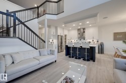 Open-concept living space with a contemporary staircase featuring dark wood and black metal balusters - 