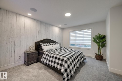 Bedroom featuring a distressed wood-paneled accent wall, recessed lighting, and built-in ceiling speakers - 1776 Crossbill Loop Nw, Edmonton, AB - Indoor Photo Showing Bedroom