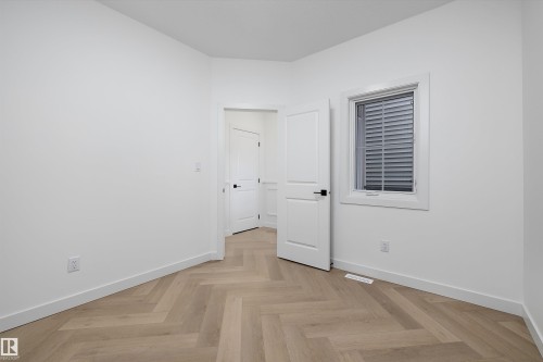 Herringbone wood-finish flooring, white walls, white trim, and a window with horizontal blinds - 1776 Crossbill Loop Nw, Edmonton, AB 