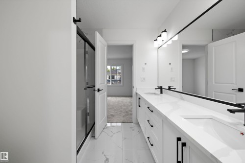Dual vanity with white countertops and undermount sinks, frameless mirror, and black-framed glass shower enclosure - 1776 Crossbill Loop Nw, Edmonton, AB 