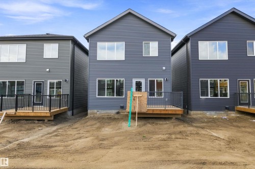 New construction townhomes featuring modern gray fiber cement siding, peaked rooflines, and multi-pane windows - 1776 Crossbill Loop Nw, Edmonton, AB 