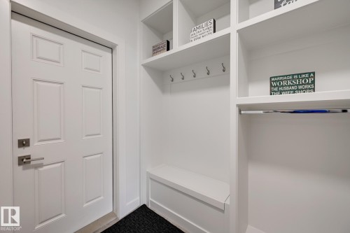 White paneled entry door with brushed nickel hardware, complemented by an integrated mudroom system - 1776 Crossbill Loop Nw, Edmonton, AB - Indoor