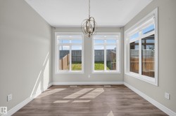 Spacious room featuring wood-finish flooring, light grey walls, and white trim - 