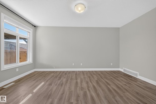 Expansive room featuring wood-finish flooring, light gray walls, and white trim - 4620 Alwood Way Sw, Edmonton, AB - Indoor Photo Showing Other Room