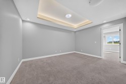 Carpeted room featuring a tray ceiling with recessed lighting, white baseboards, and neutral wall paint - 