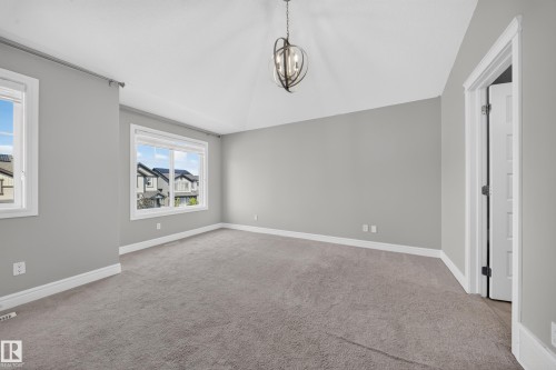 Spacious room with vaulted ceilings and a bronze-finish chandelier - 4620 Alwood Way Sw, Edmonton, AB - Indoor Photo Showing Other Room