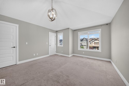 Spacious room featuring neutral carpeting, light gray walls, and white trim - 4620 Alwood Way Sw, Edmonton, AB - Indoor Photo Showing Other Room