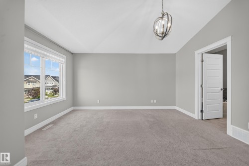 Spacious room featuring vaulted ceilings, a contemporary orb chandelier, light gray wall paint, and white trim - 4620 Alwood Way Sw, Edmonton, AB - Indoor Photo Showing Other Room