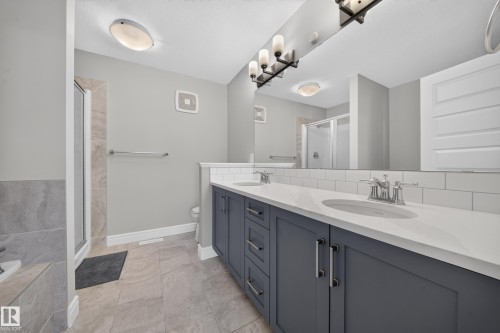 Double vanity featuring gray shaker-style cabinetry, white countertops, and chrome hardware - 4620 Alwood Way Sw, Edmonton, AB - Indoor Photo Showing Bathroom