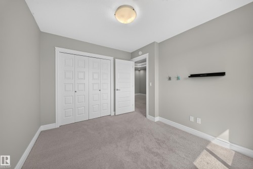 Interior room with light gray walls, gray carpeting, white baseboards, and white bi-fold closet doors - 4620 Alwood Way Sw, Edmonton, AB - Indoor Photo Showing Other Room