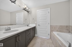 Double vanity featuring dark wood-finish cabinetry, quartz countertops, and dual undermount sinks - 