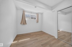 Room featuring light wood-finish flooring, white walls, and a window with a valance - 