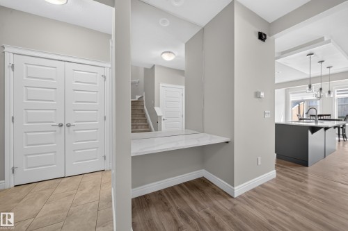 Built-in desk nook with a white marble-look surface, light gray walls, and wood-finish flooring - 4620 Alwood Way Sw, Edmonton, AB - Indoor