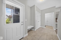 Entryway featuring light neutral wall paint, tile flooring, a built-in bench, and white panel doors - 