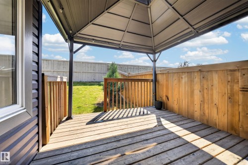 Wood-finish deck with a built-in gazebo featuring a slatted roof and dark metal frame - 4620 Alwood Way Sw, Edmonton, AB - Outdoor With Deck Patio Veranda With Exterior