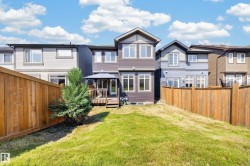 Spacious rear yard featuring natural grass landscaping and a full privacy fence - 