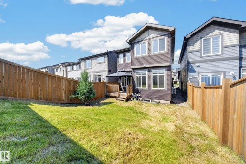 Expansive backyard featuring a lush lawn, privacy fencing, and a mature evergreen shrub - 4620 Alwood Way Sw, Edmonton, AB - Outdoor