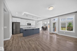 Spacious open-concept living area featuring wood-finish flooring - 