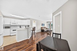 Open-concept living area with wood-finish flooring extending into the living room - 