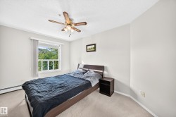Bedroom featuring neutral carpeting, light-colored walls, and a multi-pane window - 