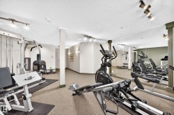 Dedicated fitness area featuring extensive mirrored walls, track lighting, and carpet flooring - 