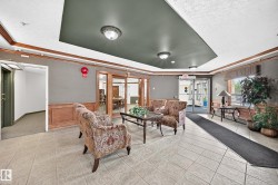 Lobby area featuring light-toned tiled flooring and wainscoting - 