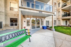 Multi-story building entrance with covered portico and concrete walkways - 
